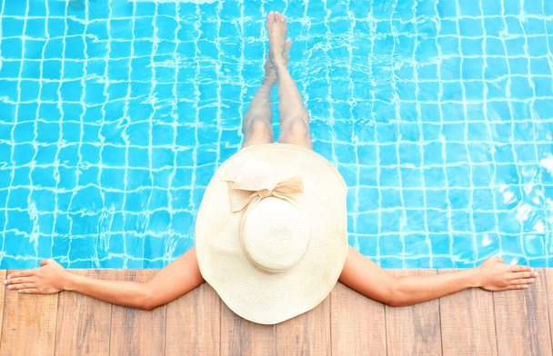 Piękne kobiece nogi i stopy na drewnianej podłodze na basenie w luksusowym kurorcie w weekendy.. - Zdjęcie, obraz