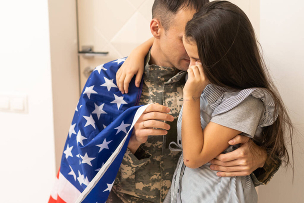 uma menina abraça um pai militar. O pai de uniforme militar com a filha. o regresso do veterano à família. - Foto, Imagem