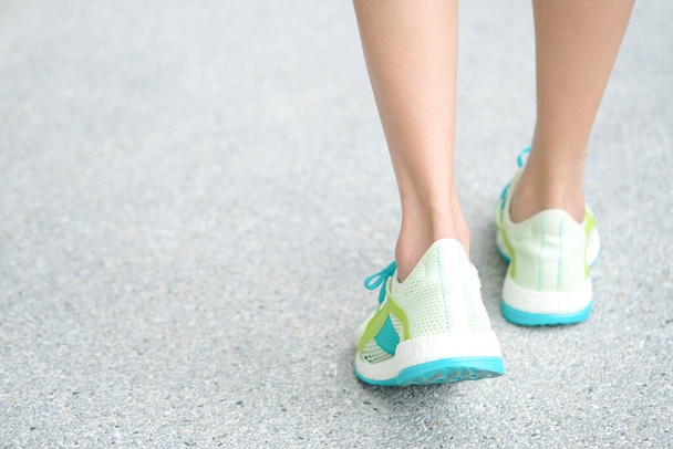 Gamba di donna che corridore atletico da scarpe da corsa è a terra per camminare esercizio al mattino. Concetti di salute e relax. Stile di vita sano - Foto, immagini