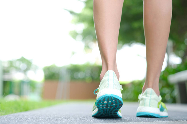 Leg of woman which runner athletic by running shoes is on the ground to walk exercise in the morning. Health and Relaxation Concepts. Healthy lifestyle - Photo, Image