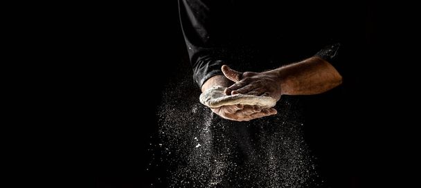 Clap hands of baker with flour. Beautiful and strong men's hands knead the dough make bread, pasta or pizza. Powdery flour flying into air. - Photo, Image