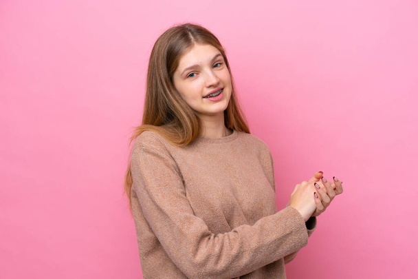 Adolescente russo menina isolada no fundo rosa aplaudindo - Foto, Imagem