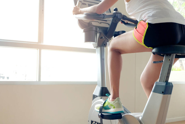 Sabahları spor salonunda bisiklet süren güzel kadınların bacağı. Sağlık ve spor konsepti. - Fotoğraf, Görsel