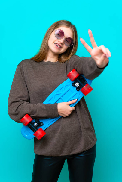 十代のスケーター女の子絶縁上の青の背景 - 写真・画像