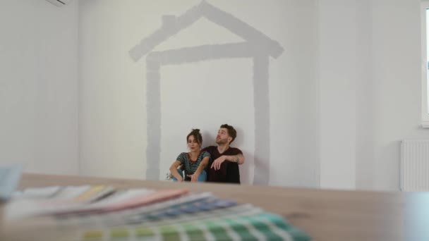 Kaukázusi pár pihen az új ház falfestése után. Lövés RED hélium kamerával 8K-ban  - Felvétel, videó