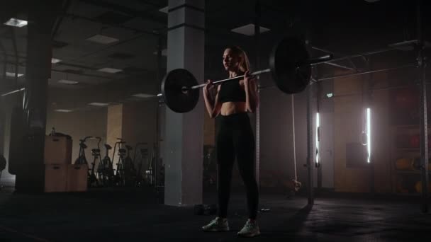 Athlétique belle femme fait Overhead Deadlift avec un haltère dans la salle de gym. Athlète féminine forte avec des poids musculaires de levage du corps, l'exercice avec haltère. femmes faisant de l'exercice avec des poids dans la salle de gym - Séquence, vidéo