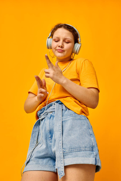 portrait of a young woman yellow t-shirt headphones entertainment music fun cropped view unaltered - Fotoğraf, Görsel