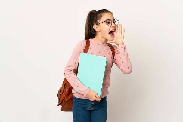Menina estudante sobre fundo isolado gritando com a boca bem aberta para o lado - Foto, Imagem