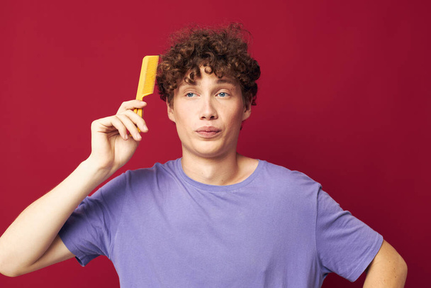 portrait of a young curly man in purple t-shirts with a comb Youth style - Fotoğraf, Görsel