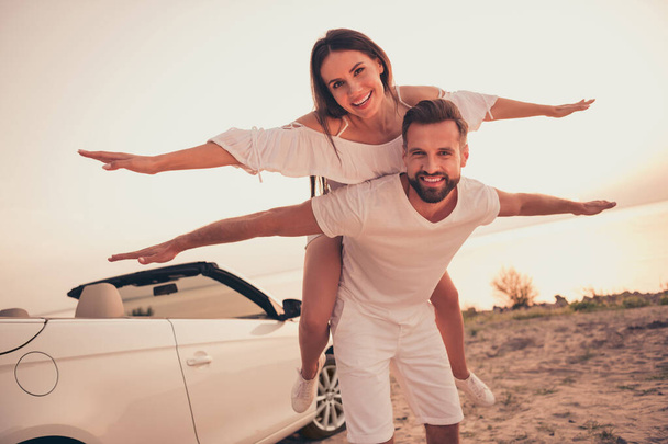 Photo portrait couple laughing together playing outside on beach near cabriolet car - Photo, Image