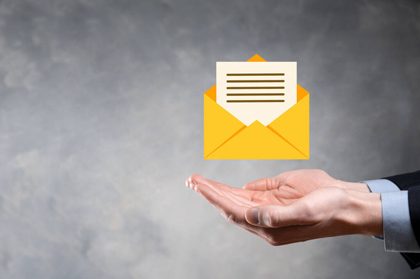 Businessman hand holding e-mail icon, Contact us by newsletter email and protect your personal information from spam mail. Customer service call center contact us concept. - Foto, Imagem