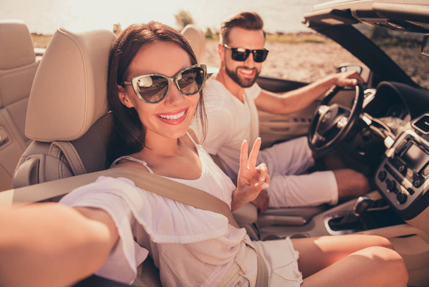 Photo of husband wife road trip journey ride automobile transport honeymoon summer season shoot selfie show v-symbol outdoors - Photo, Image