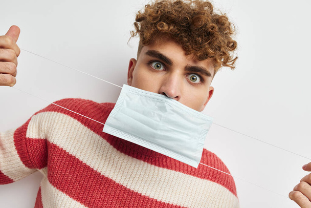 man in striped sweater medical mask health safety - 写真・画像