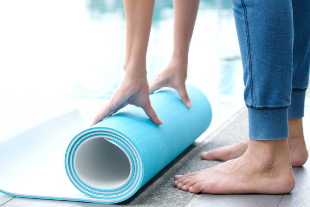 As mulheres são rolos azuis de tapete de ioga. Sala de fitness
 - Foto, Imagem