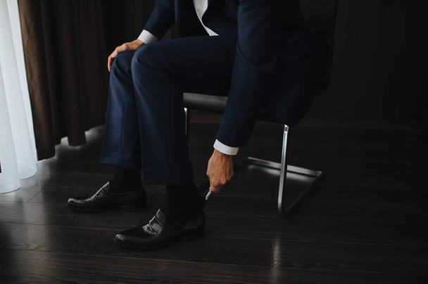 A man in a suit, the groom, close-up puts on shoes, ties his shoelaces - Foto, Imagem