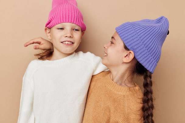 portrait of two cheerful girls in hats posing friendship - Fotó, kép