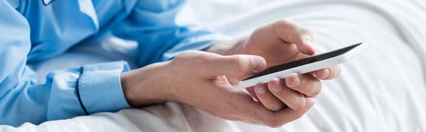 cropped view of man messaging on mobile phone in bedroom, banner - Fotoğraf, Görsel