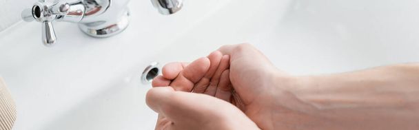 rajattu näkymä miehen pestä kädet kylpyhuoneessa, banneri - Valokuva, kuva