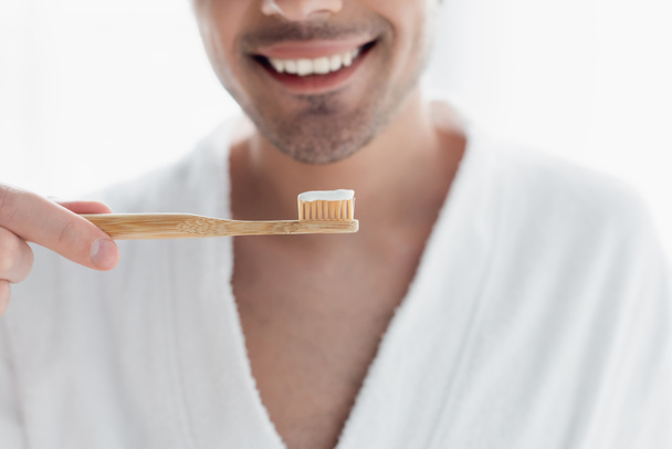 cropped view of blurred smiling man holding toothbrush with toothpaste - Photo, Image