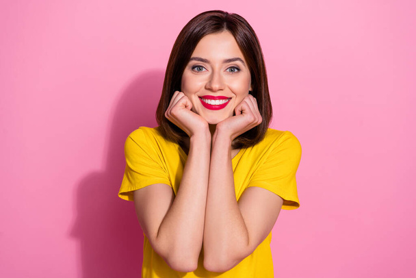 Portrait of attractive cute girlish brown-haired cheerful girl wear yellow tshirt isolated over pink pastel color background - 写真・画像