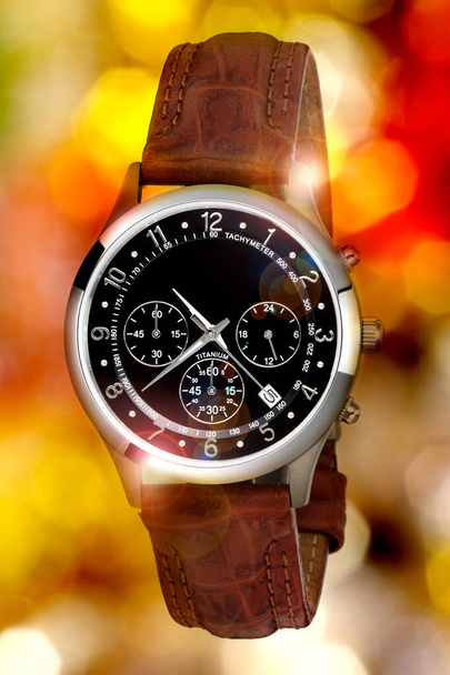 ρολόι χειρός για τον άνθρωπο σε blrury χρώμα φώτα φόντο - Φωτογραφία, εικόνα