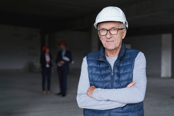 Portrait of senior man standing on construction site  - 写真・画像