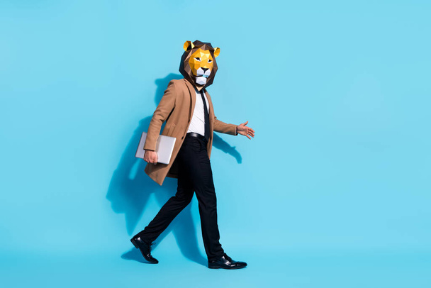 Full size profile side photo of success emloyer guy lion mask go hold netbook theme occasion showman isolated over blue color background - Φωτογραφία, εικόνα