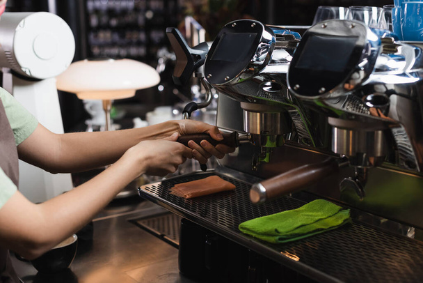 カフェでぼろきれの近くのコーヒーマシンで作業バリスタの作物ビュー  - 写真・画像