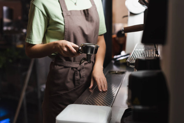 Cropped view of barista holding portafilter of coffee machine in cafe - Photo, Image