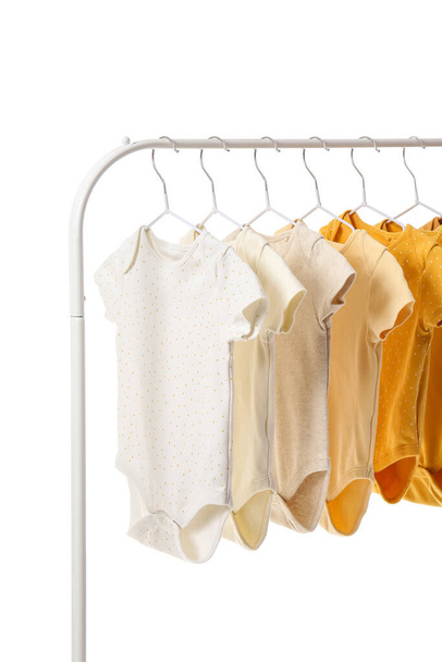Rack with different baby bodysuits on white background - Photo, Image
