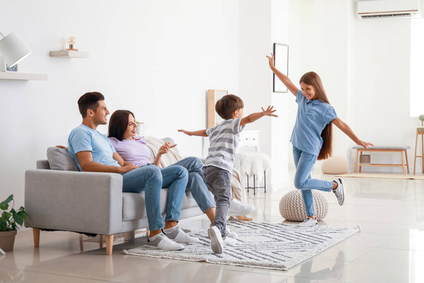 Happy parents and their dancing children at home - Photo, Image