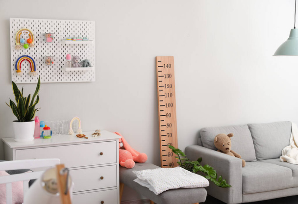 Интерьер стильной детской комнаты с комодом, диваном и пегбордом - Фото, изображение
