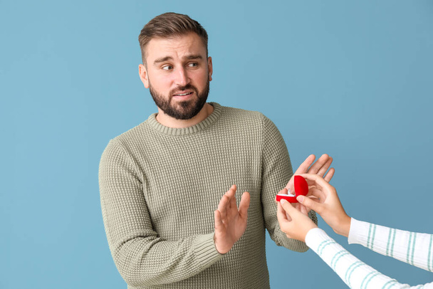 Young man rejecting marriage proposal of his girlfriend on color background - Photo, Image