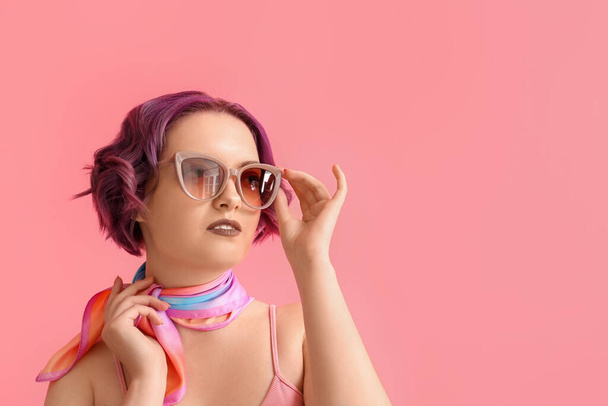 Прекрасна молода жінка з фіолетовим волоссям на рожевому тлі. Дуже барвистий 2022 рік - Фото, зображення