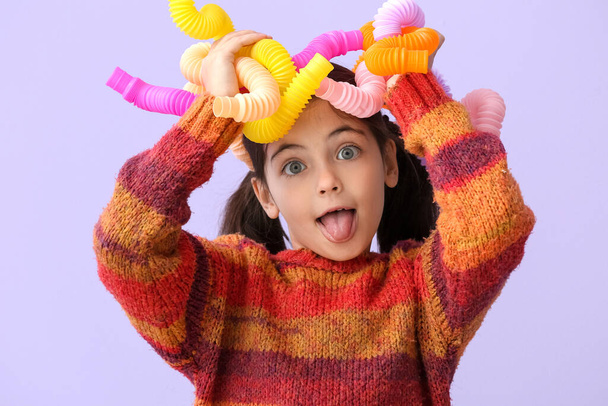 Malá dívka s pop tubes na šeříku pozadí - Fotografie, Obrázek