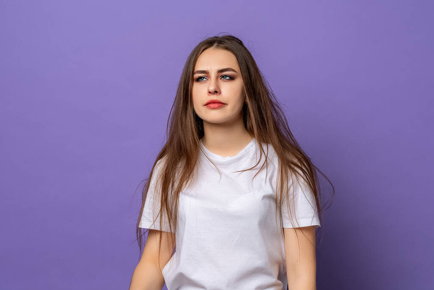 Sleepy girl, wearing casual tshirt bored, restless and sleepiness, feels weak bored, standing over purple background. Chronic fatigue syndrome, lack of sleep and energy concept - Foto, Imagem