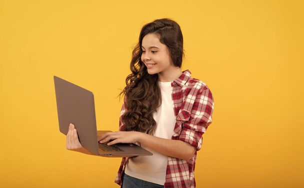 niño inteligente feliz escribiendo en el ordenador portátil durante la lección en línea de la escuela, la educación moderna - Foto, imagen