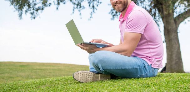 cortado sorrindo cara verificar e-mail. homem freelance post blog on-line sentar na grama. escrevendo online. - Foto, Imagem