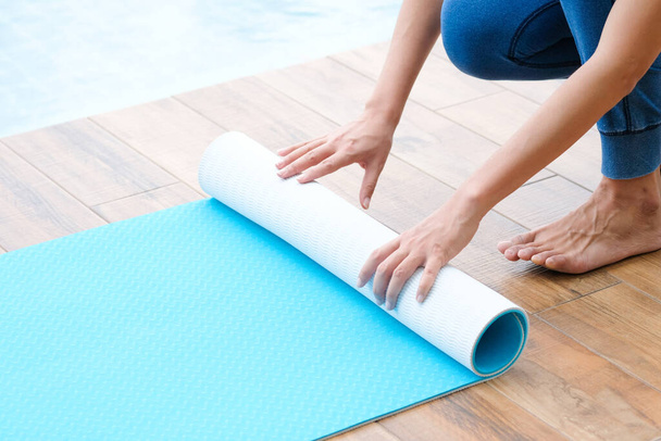 Women are yoga mat  blue rolls. Fitness room - Photo, Image
