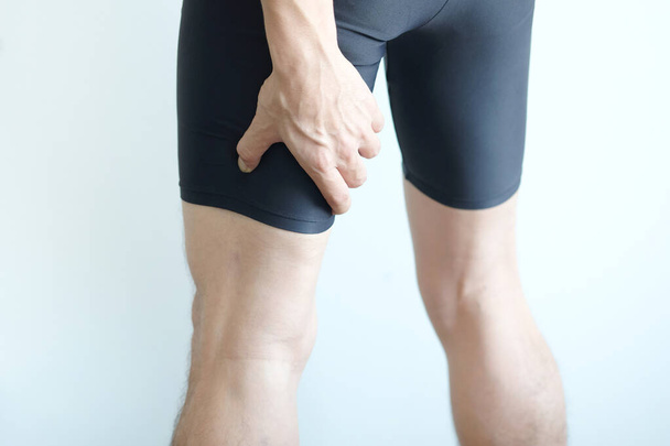 atleet heeft een been letsel en zijn dij houdt de beenspieren pijnlijk. - Foto, afbeelding