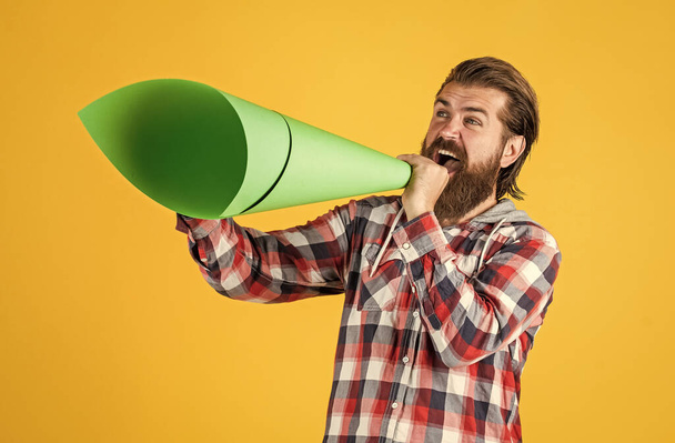mature handsome man in checkered shirt speak in paper loudspeaker, ad - Foto, afbeelding