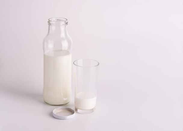 Milk bottle and glass. Fresh milk on a light background. - Fotó, kép