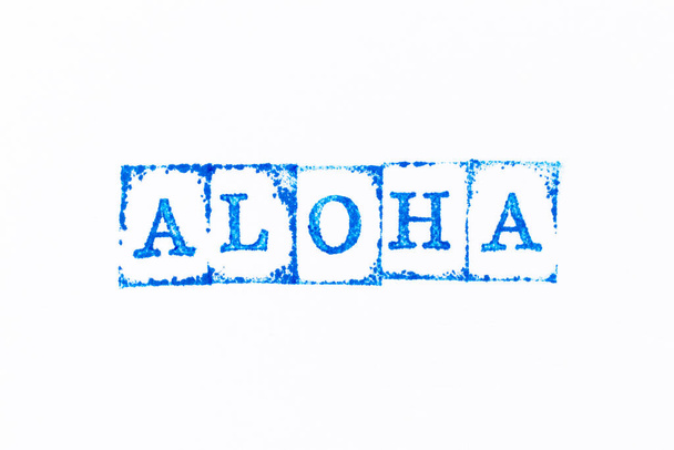 白い紙の背景に単語alohaで青の色インクゴムスタンプ - 写真・画像