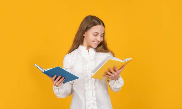 cheerful kid read school homework on yellow background, school - Fotó, kép