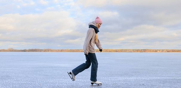 Una joven patina sobre el hielo de un lago congelado - Foto, imagen