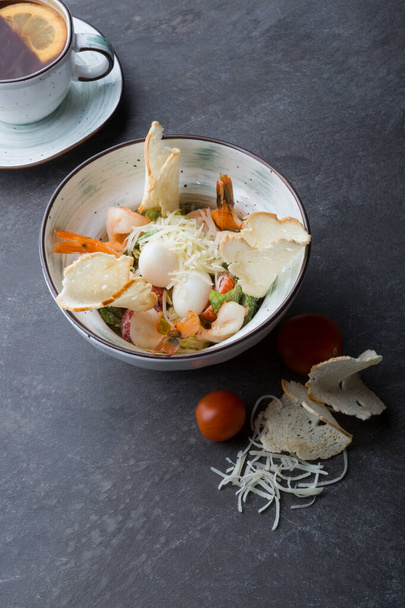 Bowl of shrimp caesar salad served for lunch on a cafe table - 写真・画像