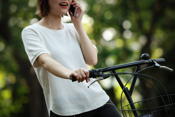 asian girl on bicycle holding a smartphone  - Foto, Imagem