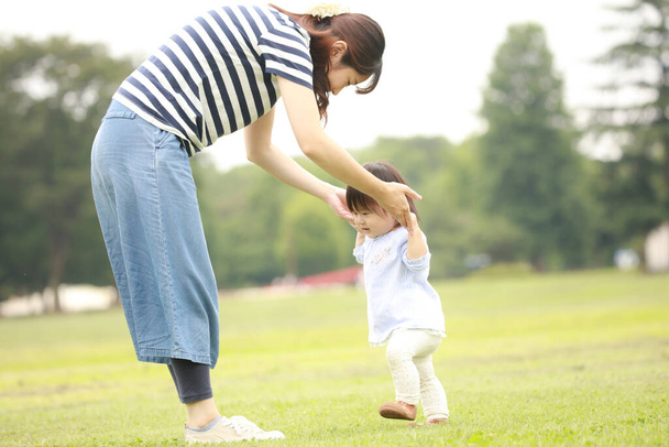 щаслива мати і дочка грають на траві
 - Фото, зображення