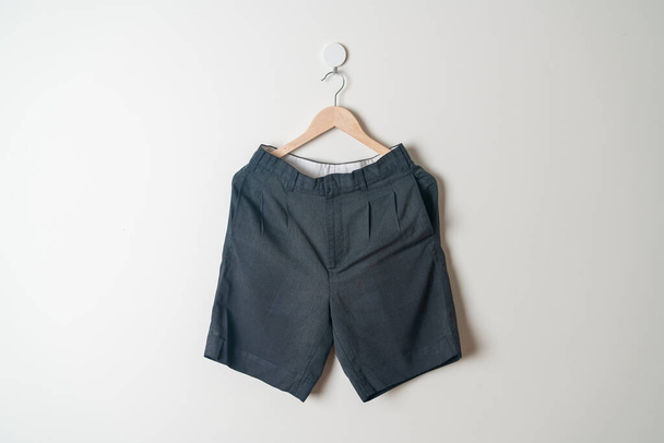 short pants hanging with wood hanger on wall - Foto, Imagen
