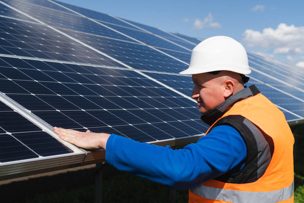 Solar plant worker inspecting photovoltaic panels for damage - Foto, imagen